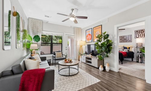 a living room with a couch, tv and tables