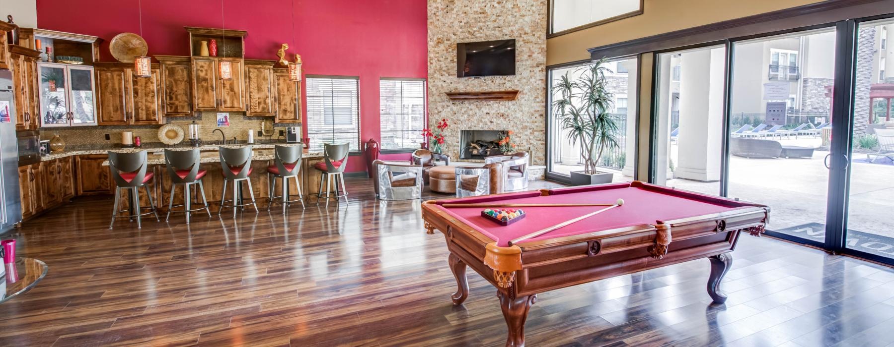 a room with a pool table and chairs
