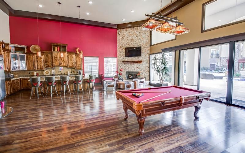 a room with a pool table and chairs